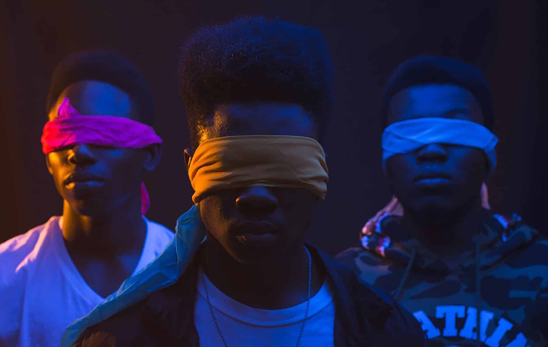unrecognizable black gang in blindfolds on dark background
